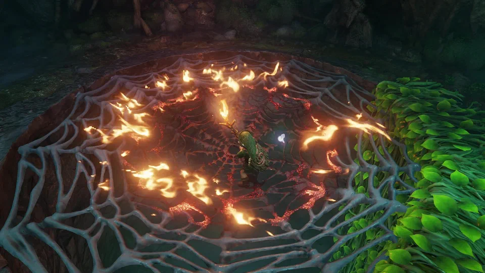 Top-down view of young Link standing on the giant spider web over the hole in the Deku Tree, holding a lit Deku Stick as a ring of flame spreads out across the web strands, embers glowing along them