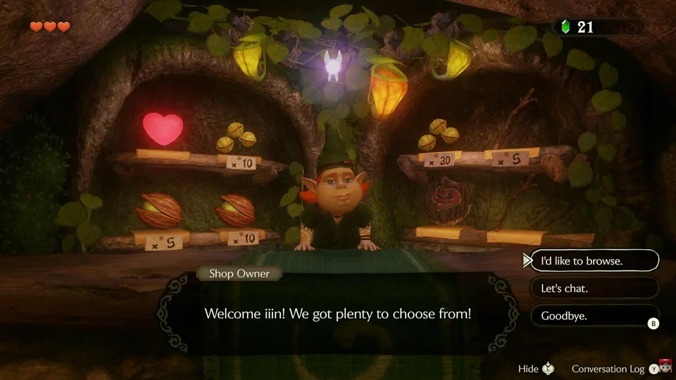 Inside the Kokiri Shop: the red-haired Shop Owner behind a counter, shelves of Deku Nuts, Deku Sticks, a Recovery Heart, and a Deku Shield with price tags, and a dialogue prompt offering browse, chat, or goodbye