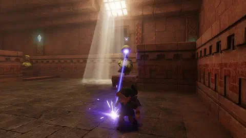 Young Link crouching on the stone floor of a sandstone Spirit Temple room as a Beamos statue on a pedestal fires a purple laser beam down at him; a second Beamos stands to the left and a shaft of light falls from a barred skylight