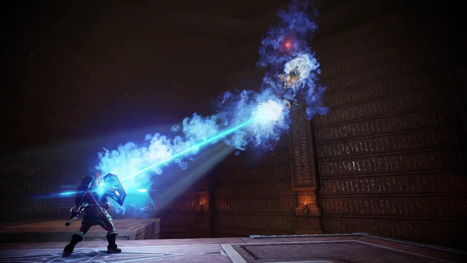 Adult Link bracing behind his raised shield as a blue ice beam from Kotake, a small witch on a broomstick high up in a glyph-covered stone arena, slams into it in a burst of blue