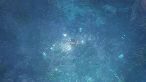 Top-down view of young Link diving down through deep blue water, arms spread, Navi above him, with glowing blue rupees scattered across the lake bed around him